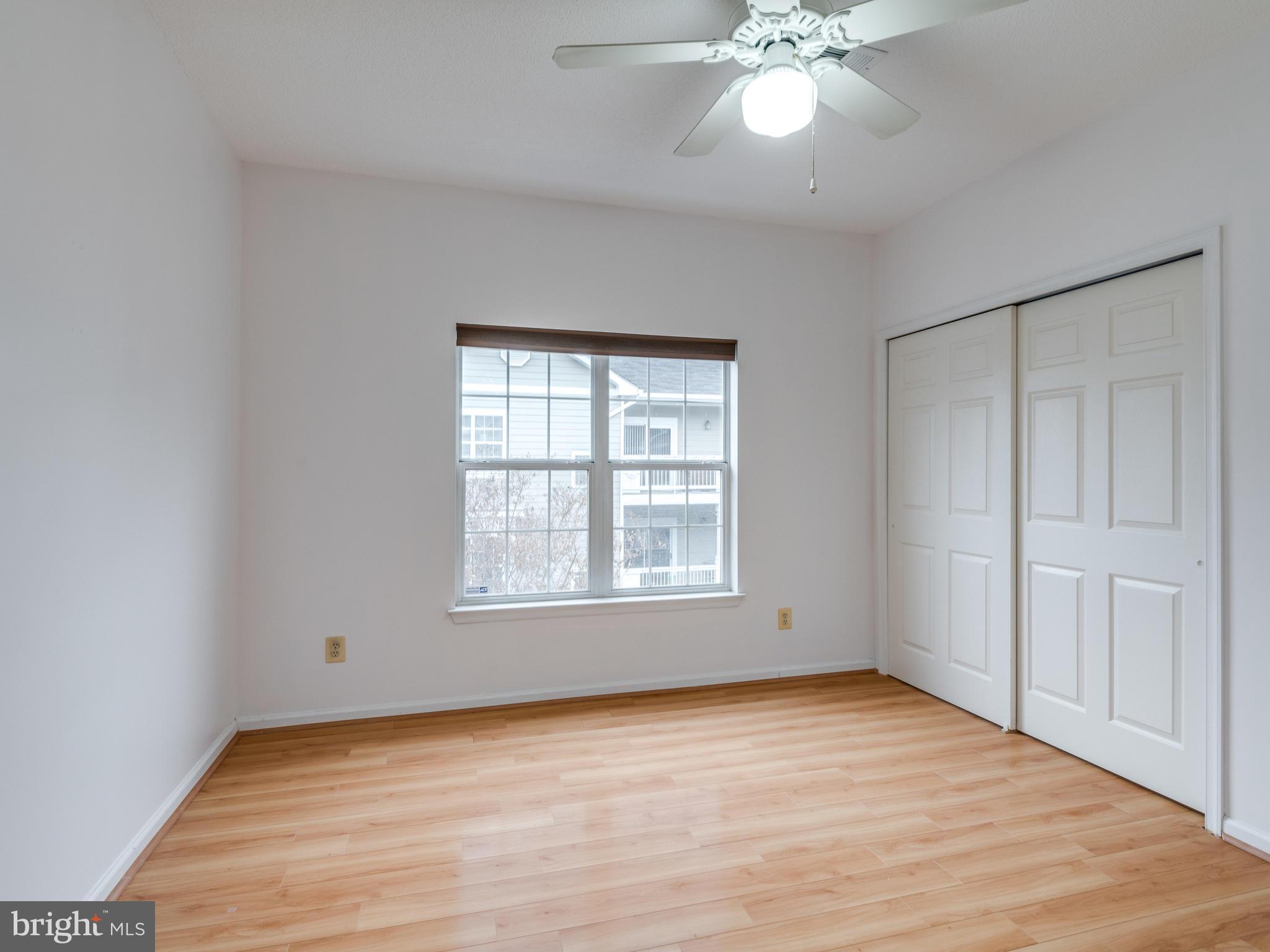 1701 Lake Shore Crest Drive, Unit 34 Reston, VA 20190 - Photo 13 of 28 a view of an empty room with wooden floor and a window