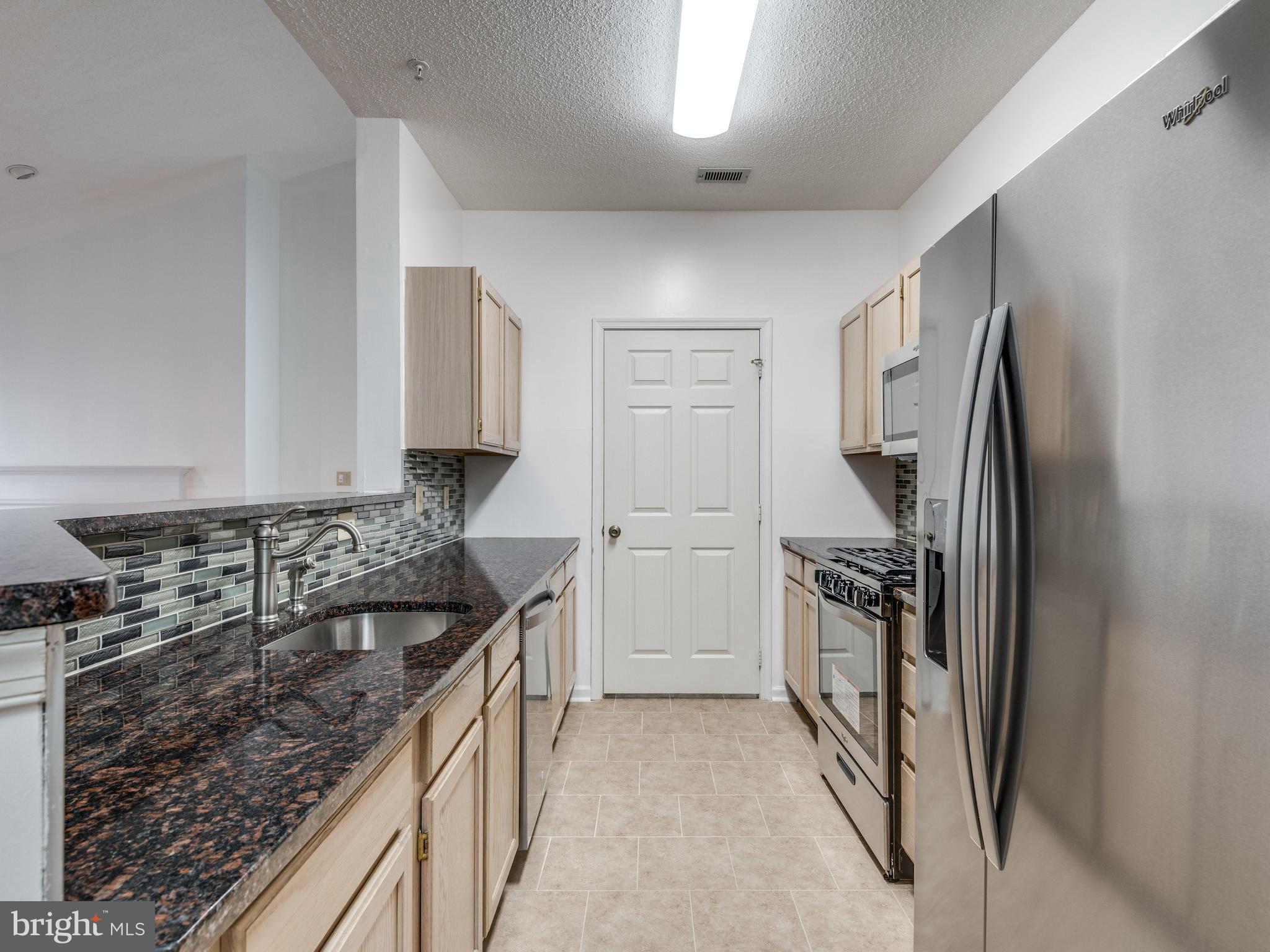 1701 Lake Shore Crest Drive, Unit 34 Reston, VA 20190 - Photo 5 of 28 a kitchen with a refrigerator stove and sink