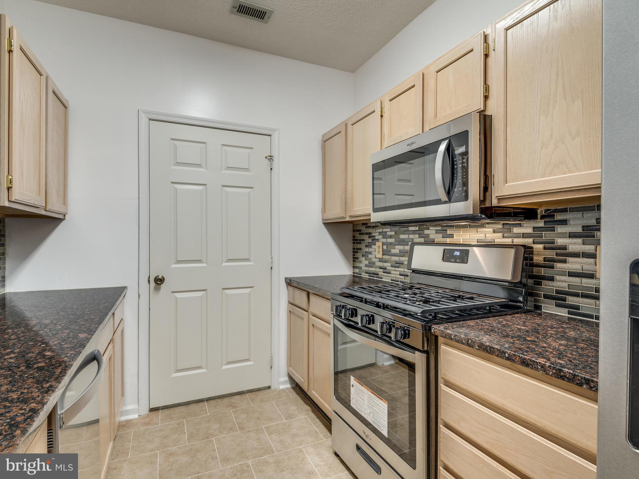 1701 Lake Shore Crest Drive, Unit 34 Reston, VA 20190 - Photo 6 of 28 a kitchen with stainless steel appliances granite countertop a stove microwave and cabinets