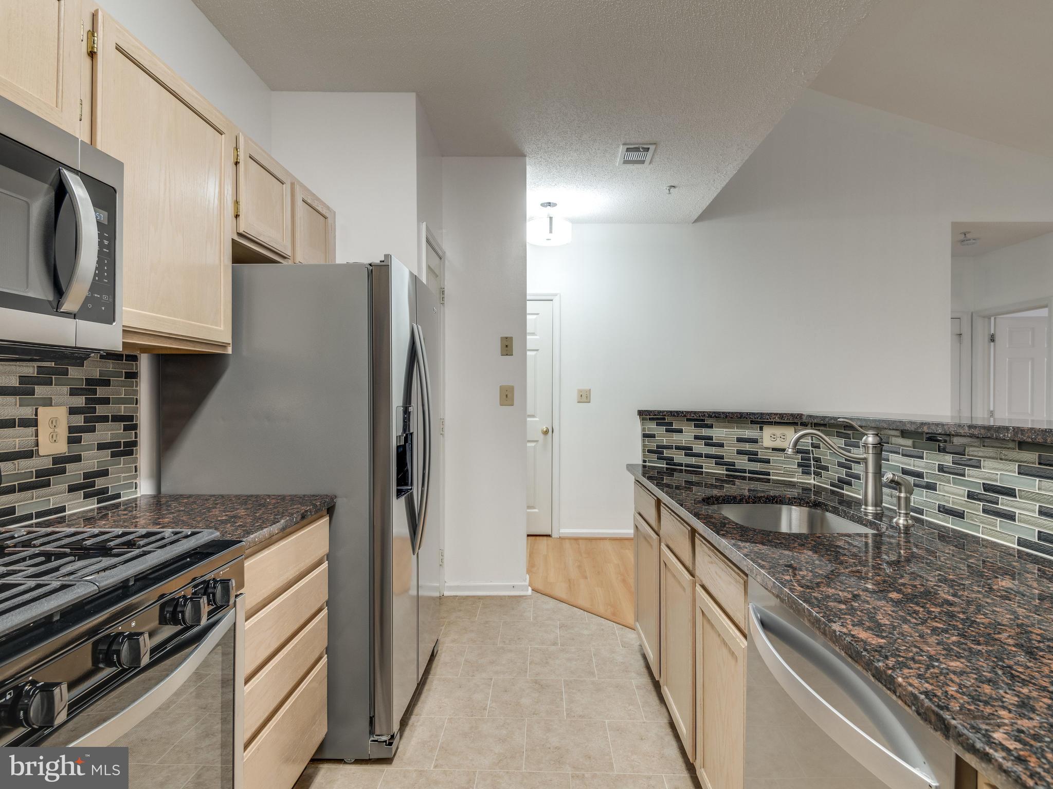 1701 Lake Shore Crest Drive, Unit 34 Reston, VA 20190 - Photo 7 of 28 a kitchen with stainless steel appliances granite countertop a stove and a refrigerator