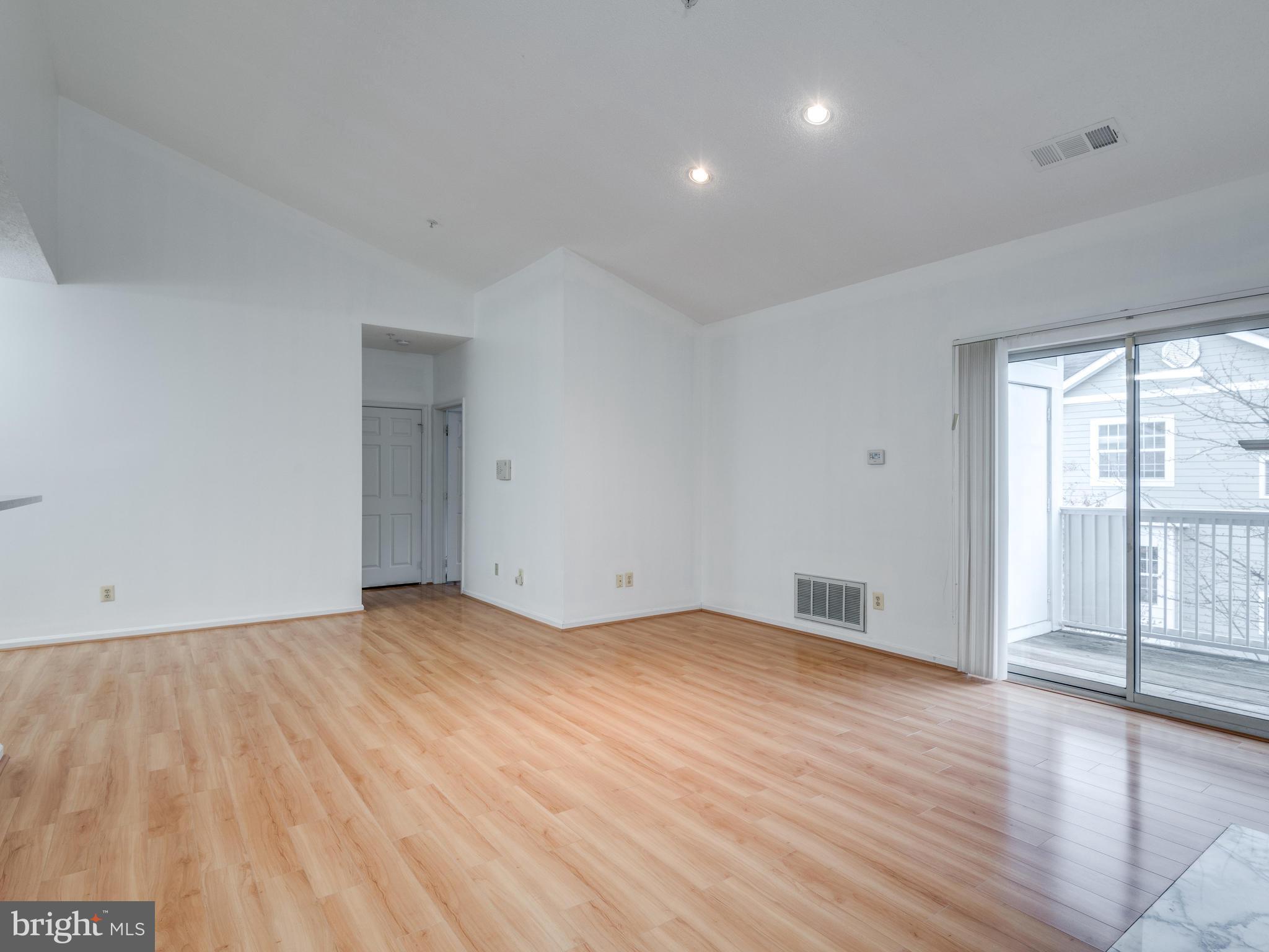 1701 Lake Shore Crest Drive, Unit 34 Reston, VA 20190 - Photo 8 of 28 a view of an empty room with wooden floor and a window