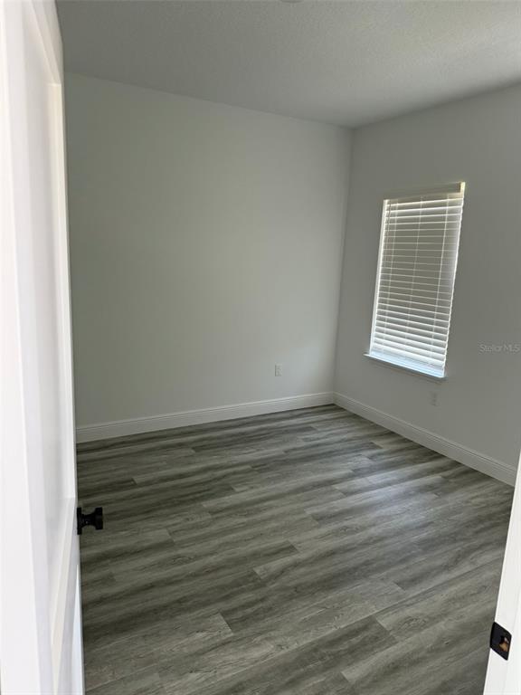 17490 Southwest 27th Circle Ocala, FL 34473 - Photo 11 of 12 a view of an empty room with wooden floor and a window