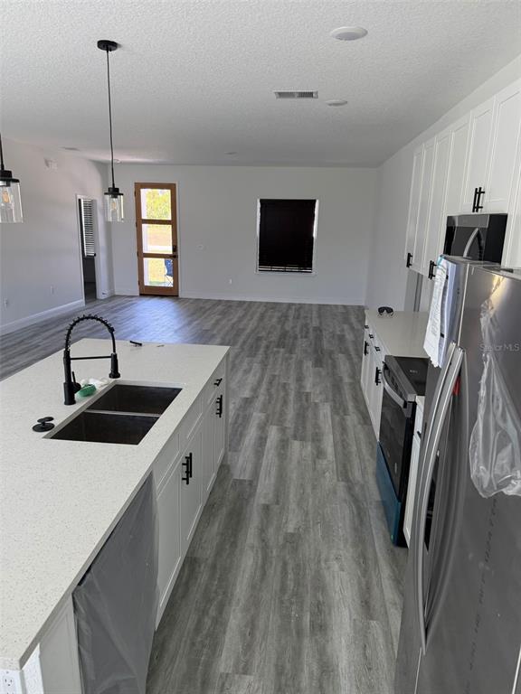 17490 Southwest 27th Circle Ocala, FL 34473 - Photo 5 of 12 a kitchen with stainless steel appliances wooden floor sink and white cabinets