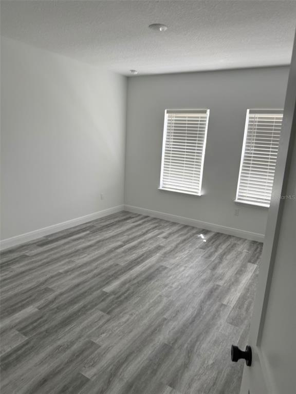17490 Southwest 27th Circle Ocala, FL 34473 - Photo 6 of 12 an empty room with wooden floor and windows