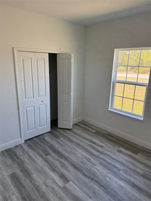 17490 Southwest 27th Circle Ocala, FL 34473 - Photo 7 of 12 a view of an empty room with wooden floor and a window