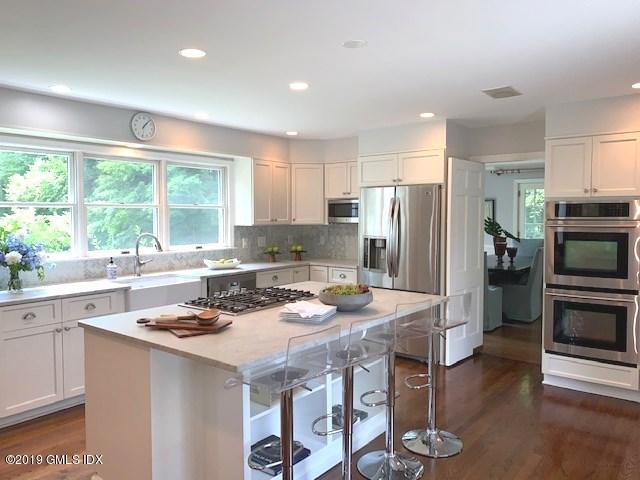 244 Stanwich Road Greenwich, CT 06830 - Photo 7 of 22 a kitchen with a refrigerator a stove a sink dishwasher with a dining table and chairs