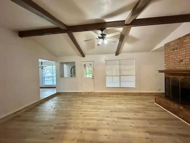a view of an empty room with a fireplace and a window