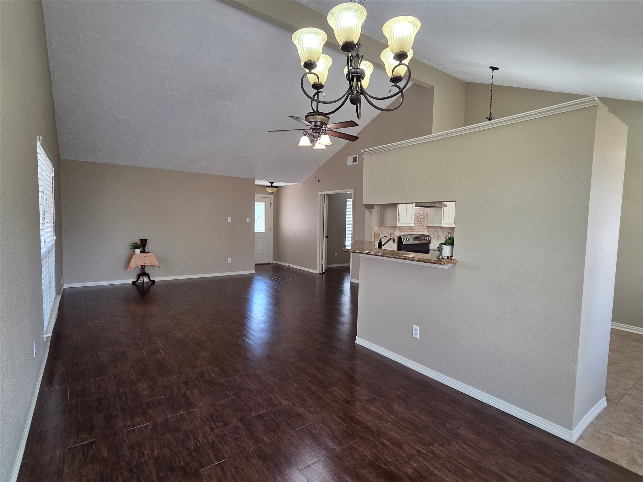4203 Spinks Creek Lane Spring, TX 77388 - Photo 5 of 14 This spacious living/dining area features high ceilings, wood look flooring, neutral walls, elegant chandelier and ceiling fan. Natural light enhances the inviting atmosphere.