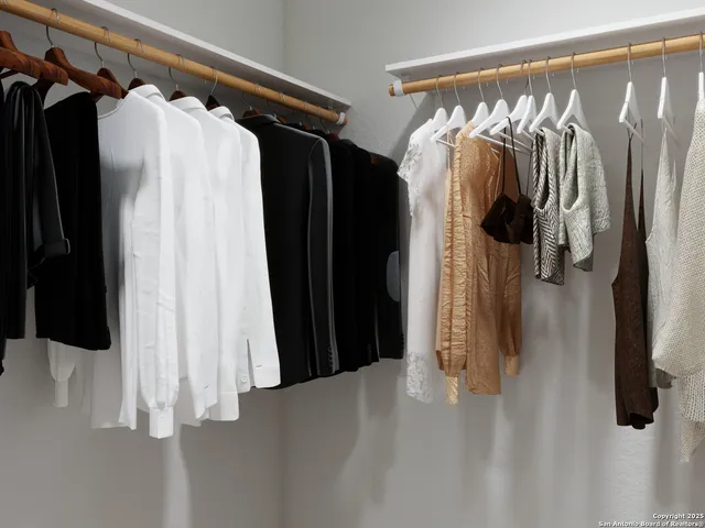 a view of walk in closet with clothes and shoes