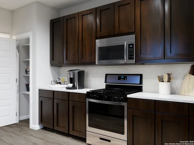 a kitchen with granite countertop wood cabinets and stainless steel appliances