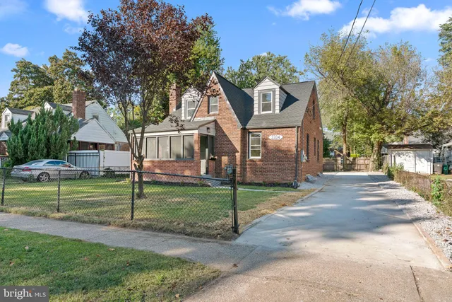 a view of a house next to a yard with big trees