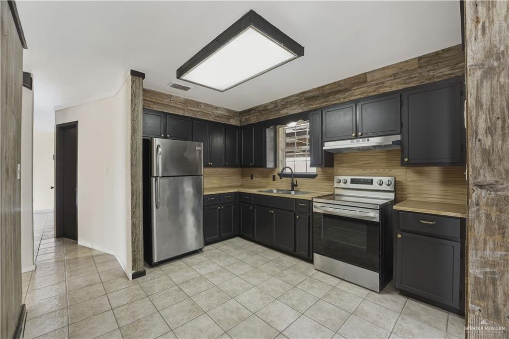 3101 Tom Gill Road Penitas, TX 78576 - Photo 7 of 16 a kitchen with stainless steel appliances granite countertop a refrigerator and a stove