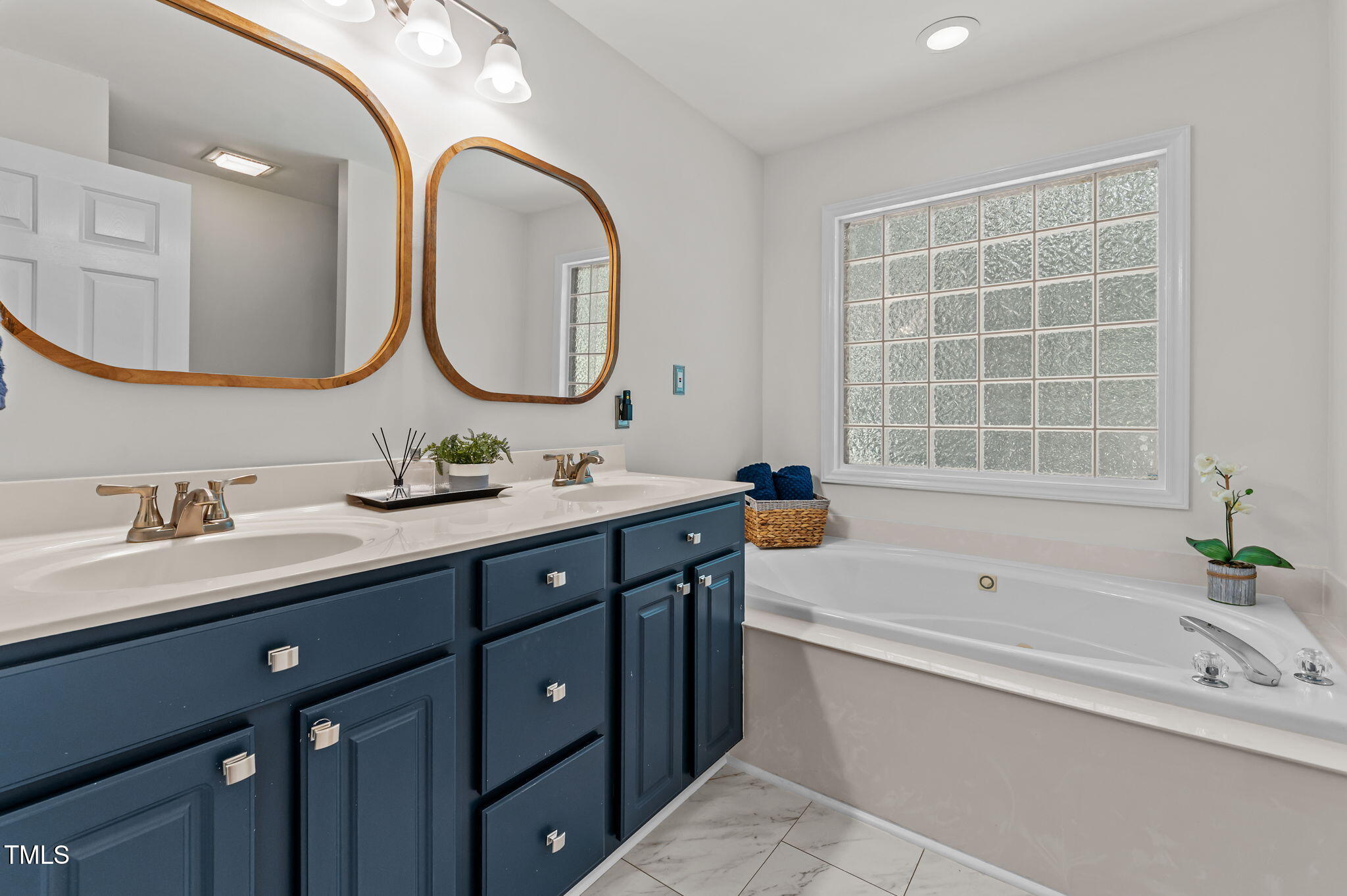 11924 Larka Court Raleigh, NC 27613 - Photo 17 of 44 a bathroom with a tub sink and mirror