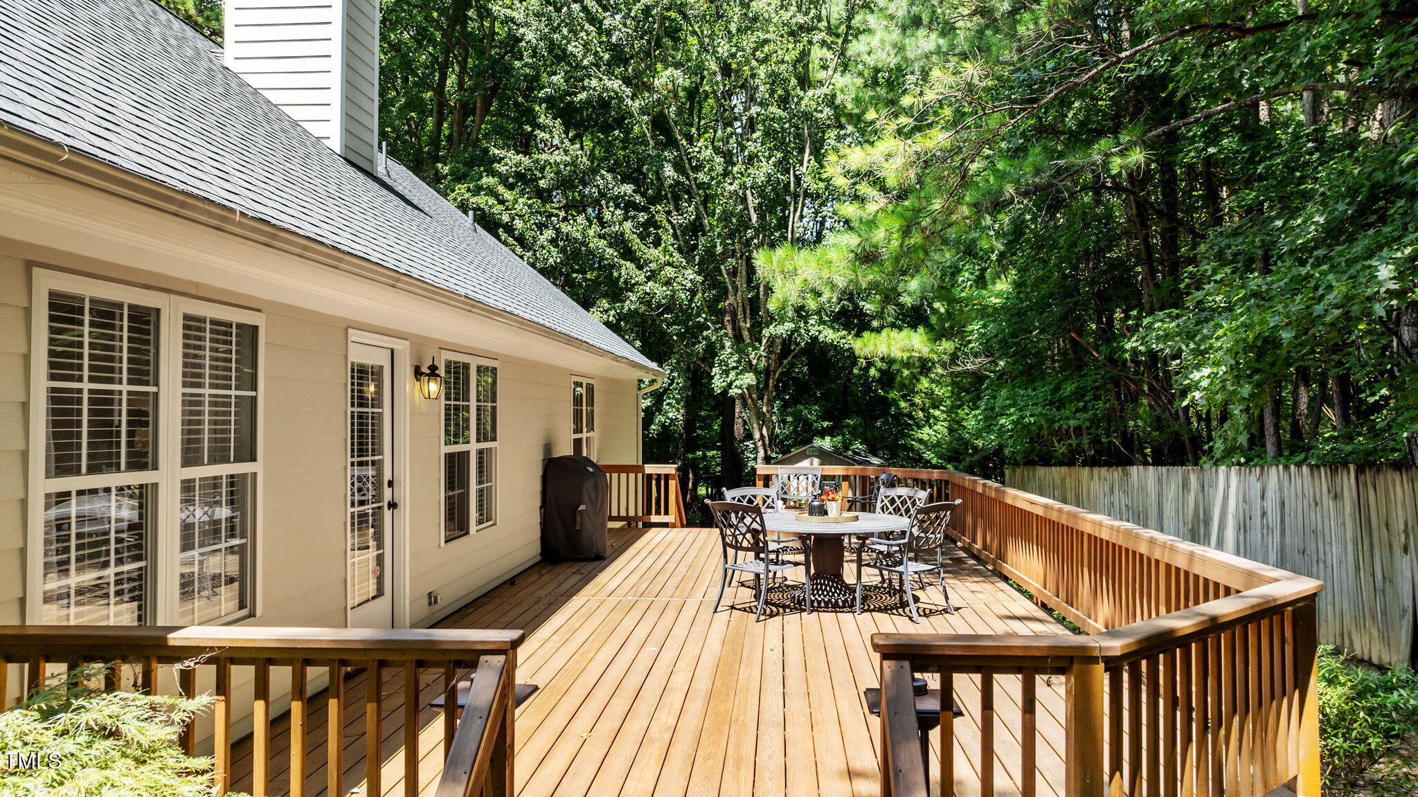 11924 Larka Court Raleigh, NC 27613 - Photo 34 of 44 a view of a patio with table and chairs with wooden floor and fence
