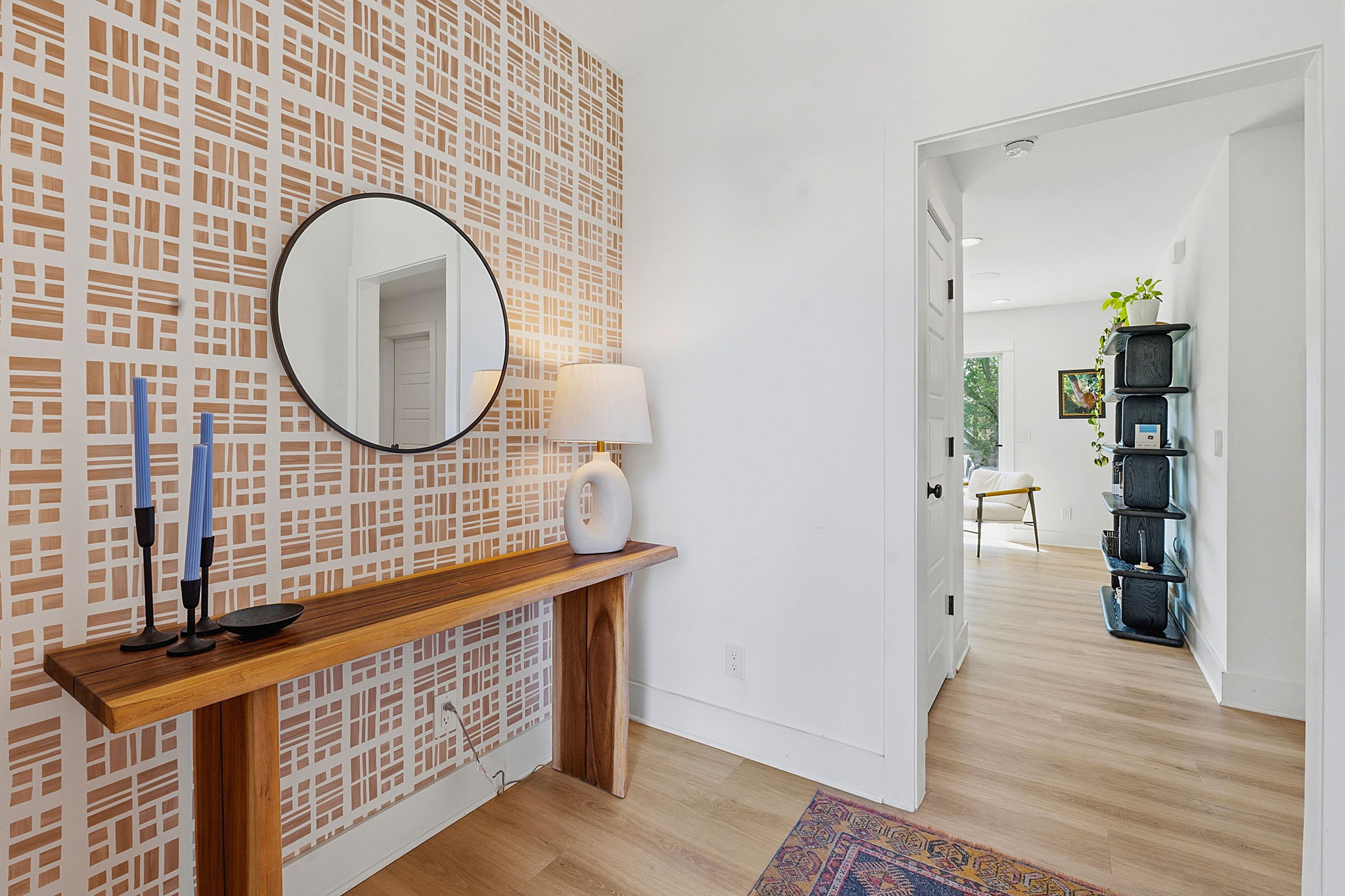 4403 Elmsgrove Drive Austin, TX 78721 - Photo 2 of 38 A welcoming entry features natural wood flooring and a stylish accent wall, opening to additional living areas.