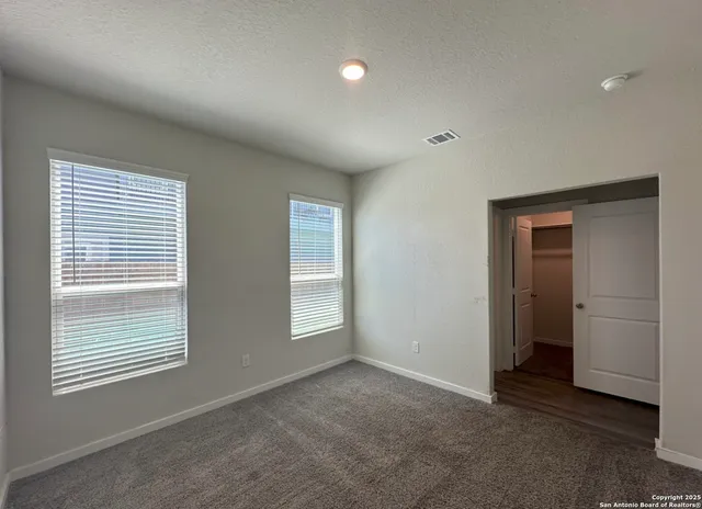 a view of an empty room with a window and a bathroom
