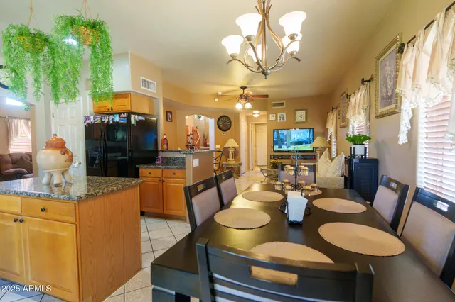 a dining room with furniture a chandelier and kitchen view