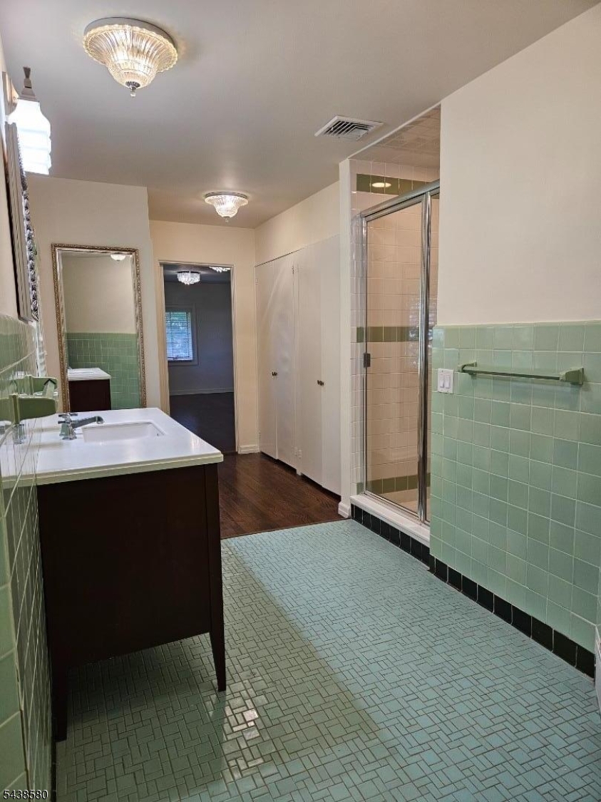 218 Devon Road Essex Fells, NJ 07021 - Photo 19 of 24 a bathroom with a double vanity sink a mirror and shower