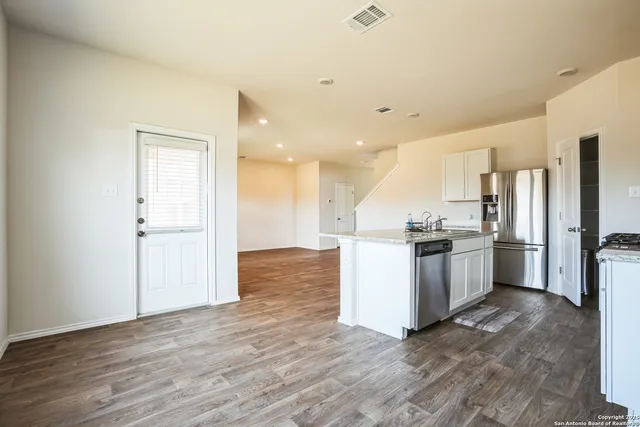 a kitchen with cabinets wooden floor and a sink