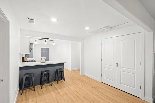 a kitchen with a sink dishwasher a stove a microwave oven with a dining table and chairs