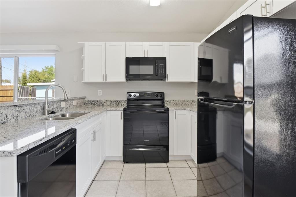 6018 Flora Terrace Apollo Beach, FL 33572 - Photo 14 of 33 a kitchen with a refrigerator a sink and a stove