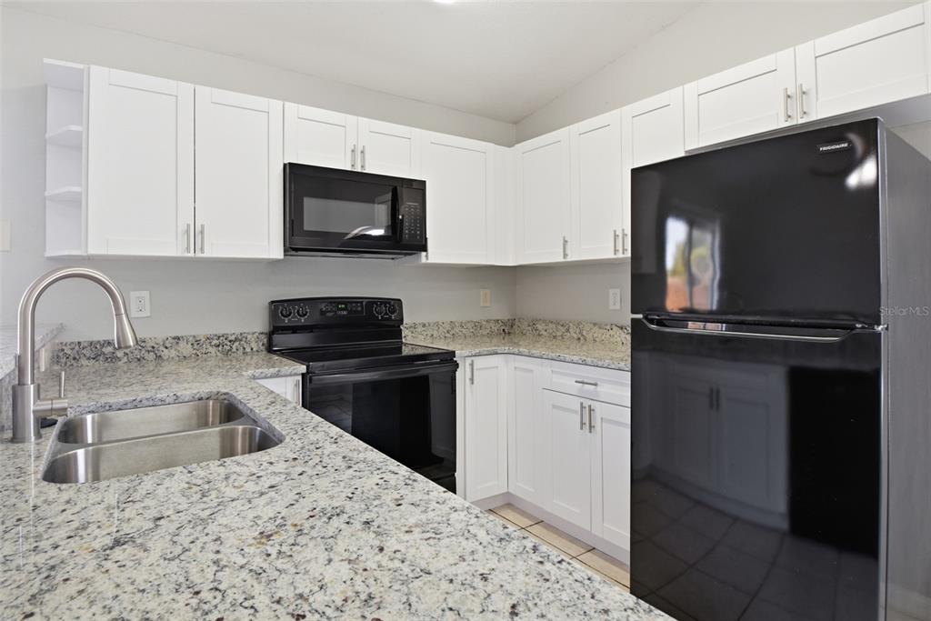 6018 Flora Terrace Apollo Beach, FL 33572 - Photo 15 of 33 a kitchen with a refrigerator stove and microwave