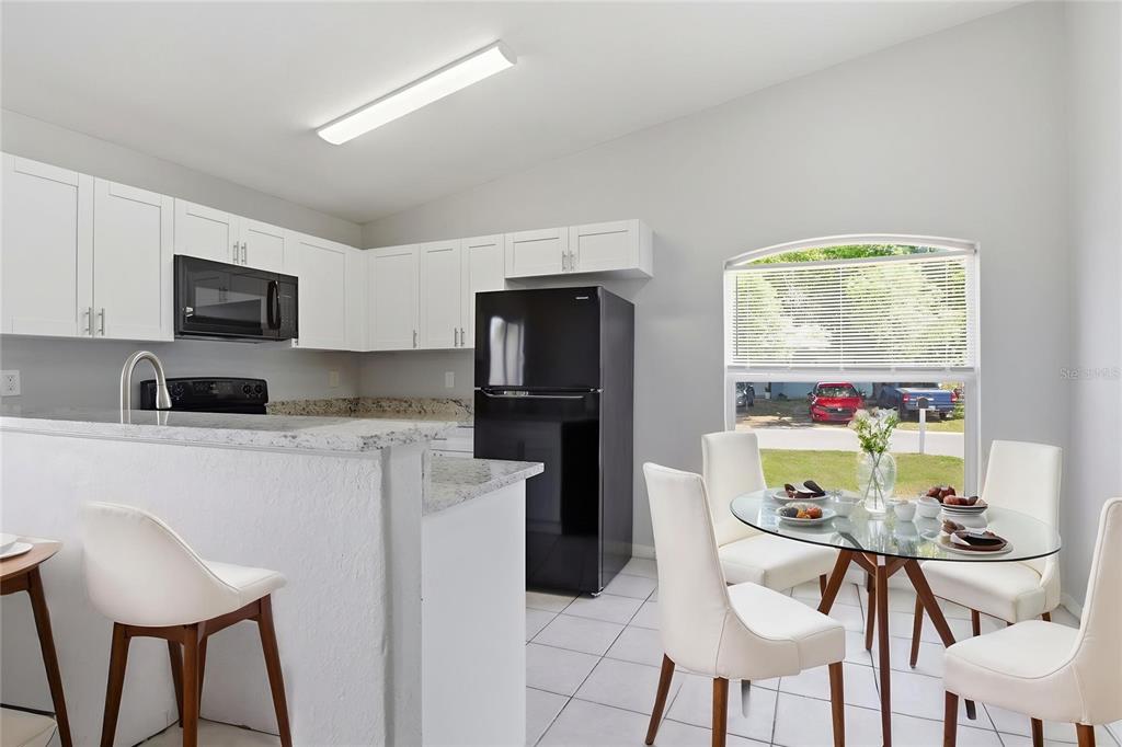 6018 Flora Terrace Apollo Beach, FL 33572 - Photo 4 of 33 a kitchen with stainless steel appliances granite countertop a table and chairs in it