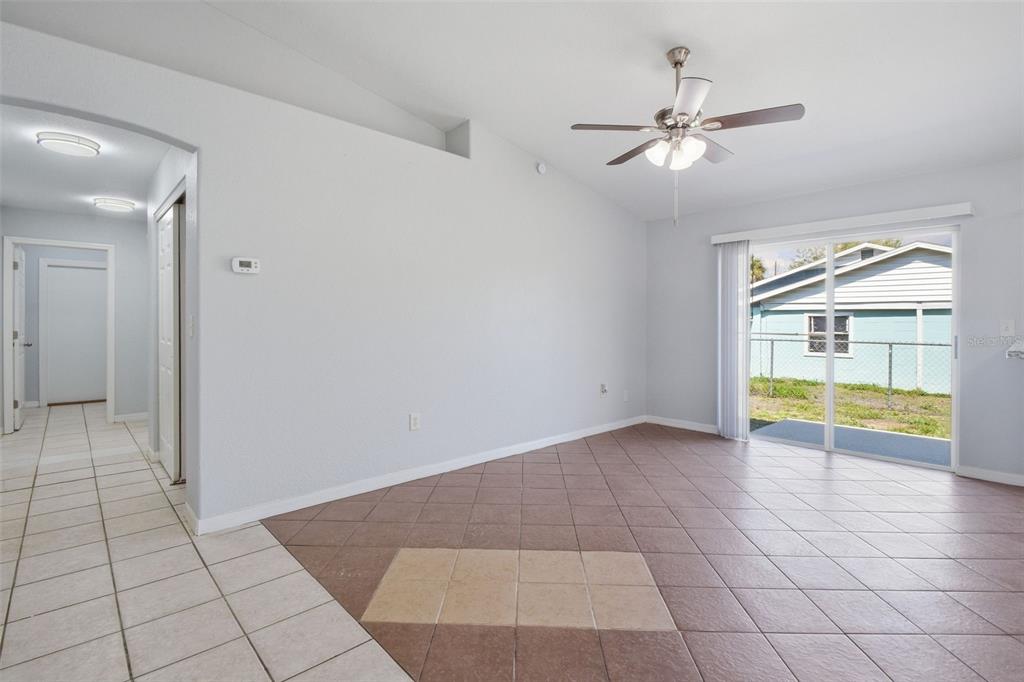 6018 Flora Terrace Apollo Beach, FL 33572 - Photo 9 of 33 an empty room with floor to ceiling fan and kitchen view