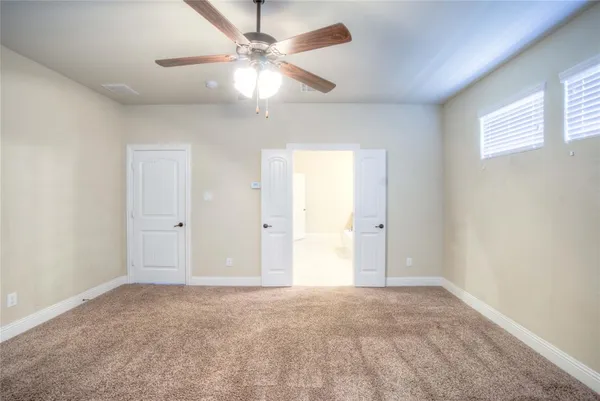 an empty room with fan and windows
