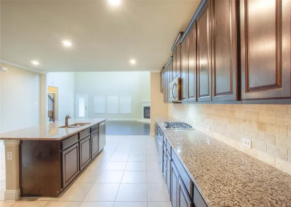 a large kitchen with kitchen island granite countertop a large counter top and wooden cabinets
