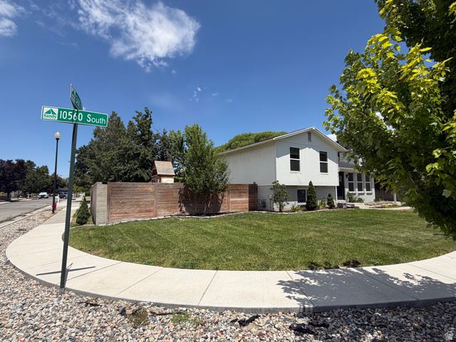 375 East 10560 South Sandy, UT 84070 - Photo 21 of 21 Corner lot with a sizable lawn, concrete sidewalk, wood privacy fence, and mature trees