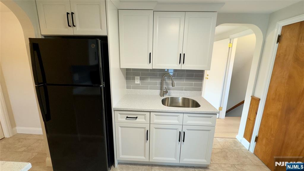 163 Center Street, Unit 2 New Milford, NJ 07646 - Photo 12 of 25 a kitchen with white cabinets and refrigerator