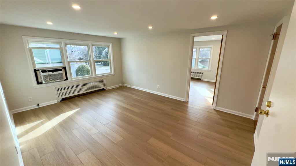 163 Center Street, Unit 2 New Milford, NJ 07646 - Photo 23 of 25 an empty room with wooden floor and windows
