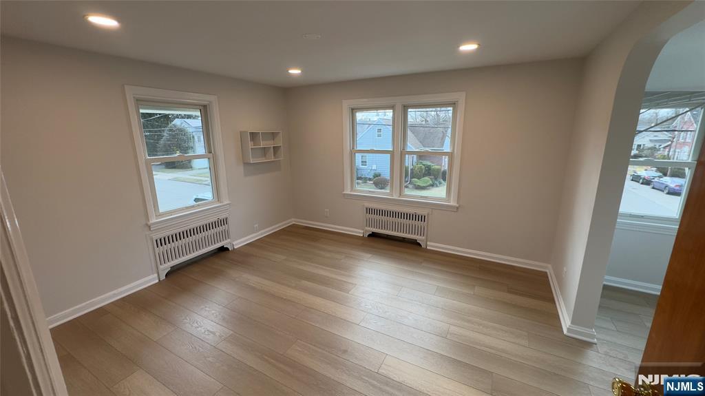163 Center Street, Unit 2 New Milford, NJ 07646 - Photo 4 of 25 an empty room with wooden floor and windows