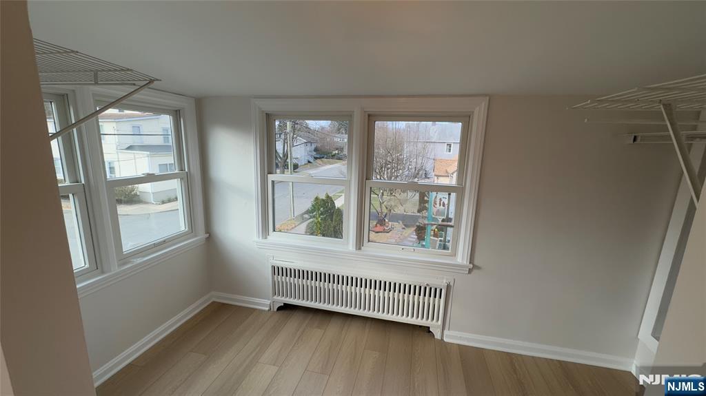163 Center Street, Unit 2 New Milford, NJ 07646 - Photo 5 of 25 a view of an empty room with wooden floor and a window