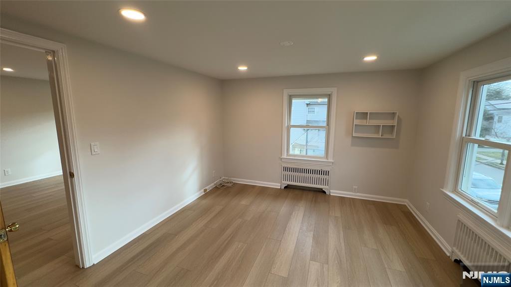163 Center Street, Unit 2 New Milford, NJ 07646 - Photo 7 of 25 an empty room with wooden floor and windows