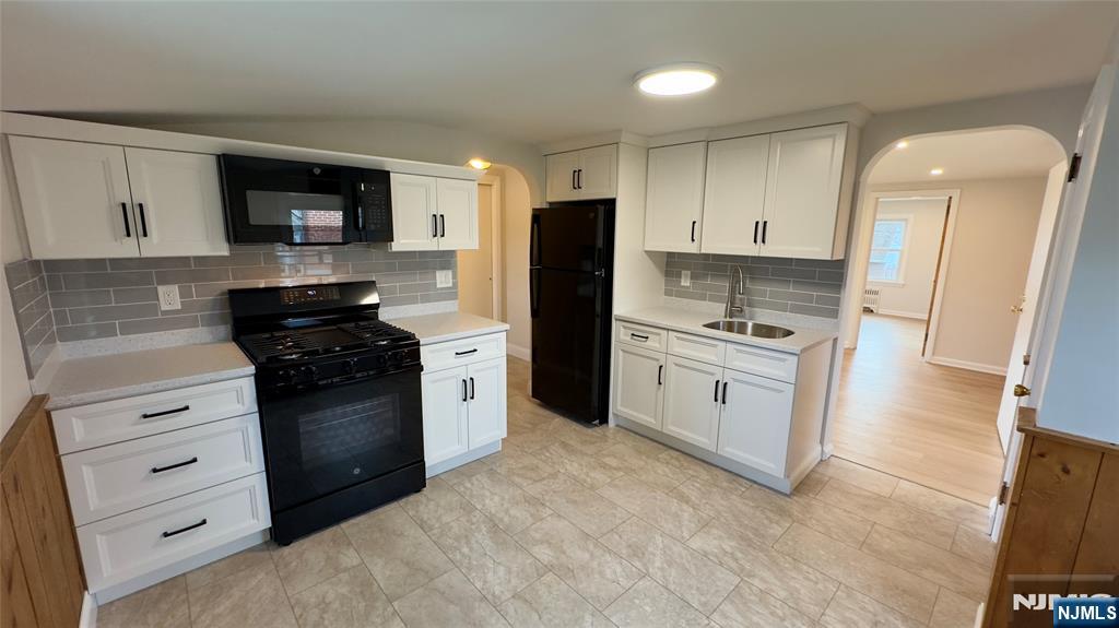 163 Center Street, Unit 2 New Milford, NJ 07646 - Photo 10 of 25 a kitchen with stainless steel appliances white cabinets and black appliances