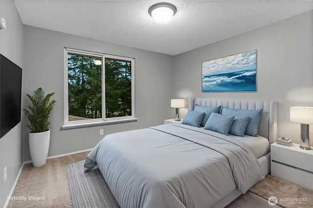 a large bed sitting in a bedroom next to a window
