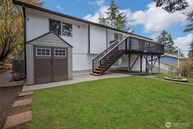 a view of a backyard with table and chairs and a large tree