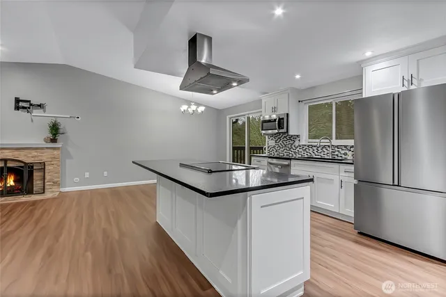 a kitchen with granite countertop stainless steel appliances and wooden floor