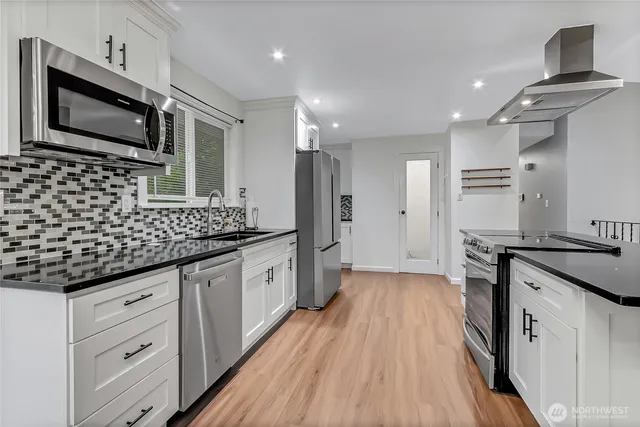 a kitchen with granite countertop a sink stove and refrigerator