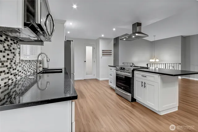 a kitchen with a sink stainless steel appliances a counter space and cabinets