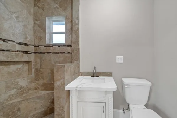 a bathroom with a sink a toilet and a mirror