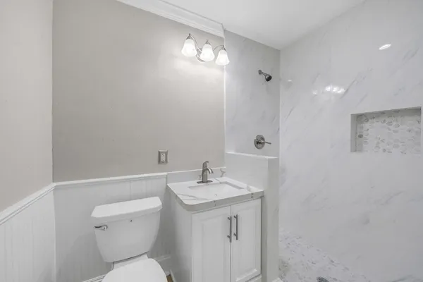 a bathroom with a toilet a sink and mirror