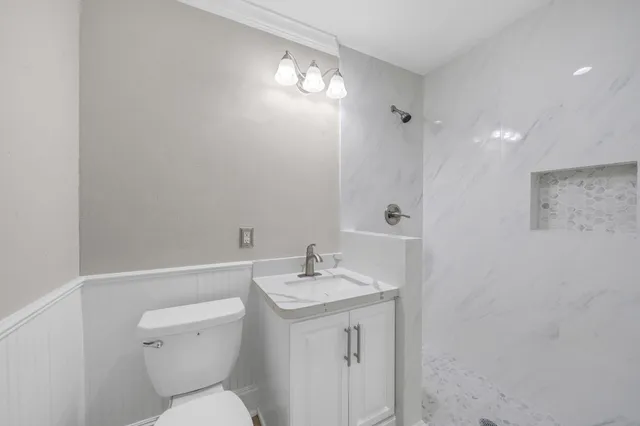 a bathroom with a toilet a sink and mirror