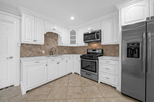 a kitchen with granite countertop a sink stove and refrigerator