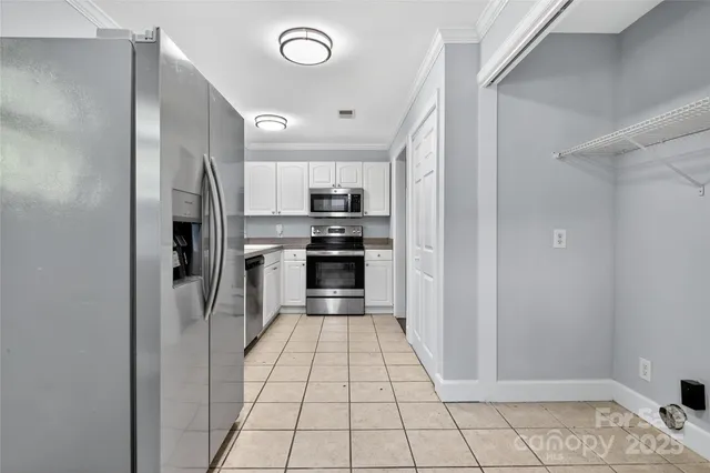 a kitchen with stainless steel appliances a refrigerator and a stove top oven