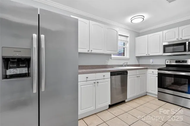 a kitchen with white cabinets and stainless steel appliances