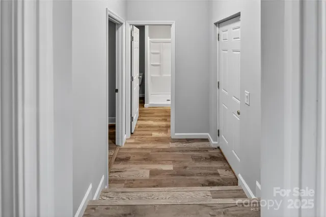 a view of a hallway with wooden floor and entryway
