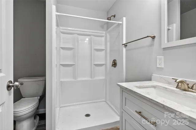 a bathroom with a granite countertop sink toilet and shower